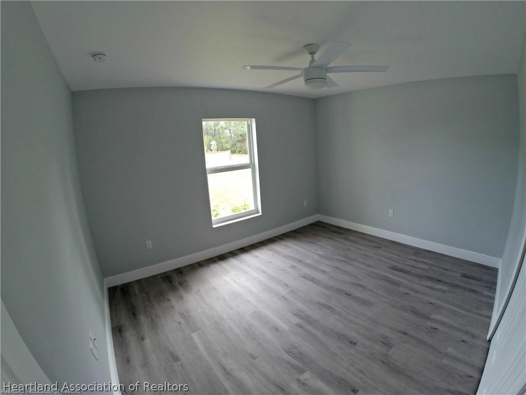 144 Lincoln Road Northwest Lake Placid, FL 33852 - Photo 14 of 19 an empty room with wooden floor and windows
