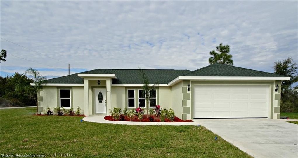 144 Lincoln Road Northwest Lake Placid, FL 33852 - Photo 3 of 19 a front view of a house with a yard and garage