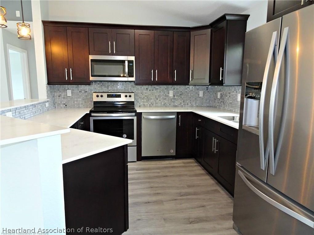 144 Lincoln Road Northwest Lake Placid, FL 33852 - Photo 6 of 19 a kitchen with a sink stove and refrigerator