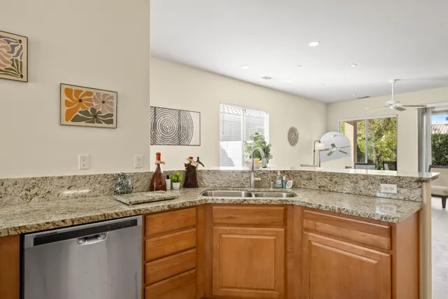 a kitchen with granite countertop a sink and cabinets