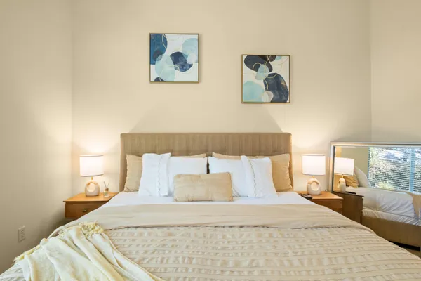 a bed room with a bed and a painting on the wall