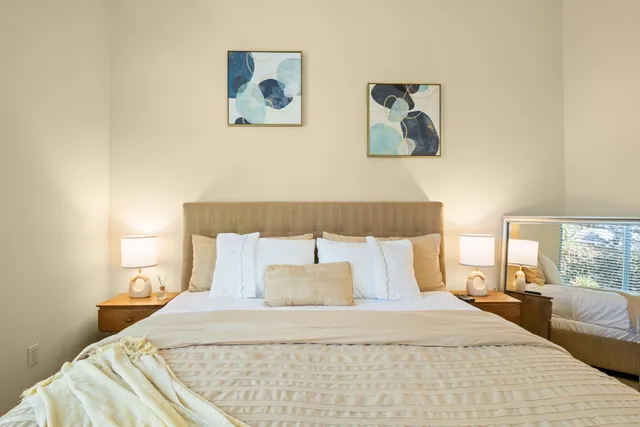 a bed room with a bed and a painting on the wall