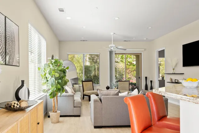 a living room with furniture a flat screen tv and a large window