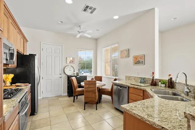 a kitchen with granite countertop a sink a counter top space appliances and cabinets