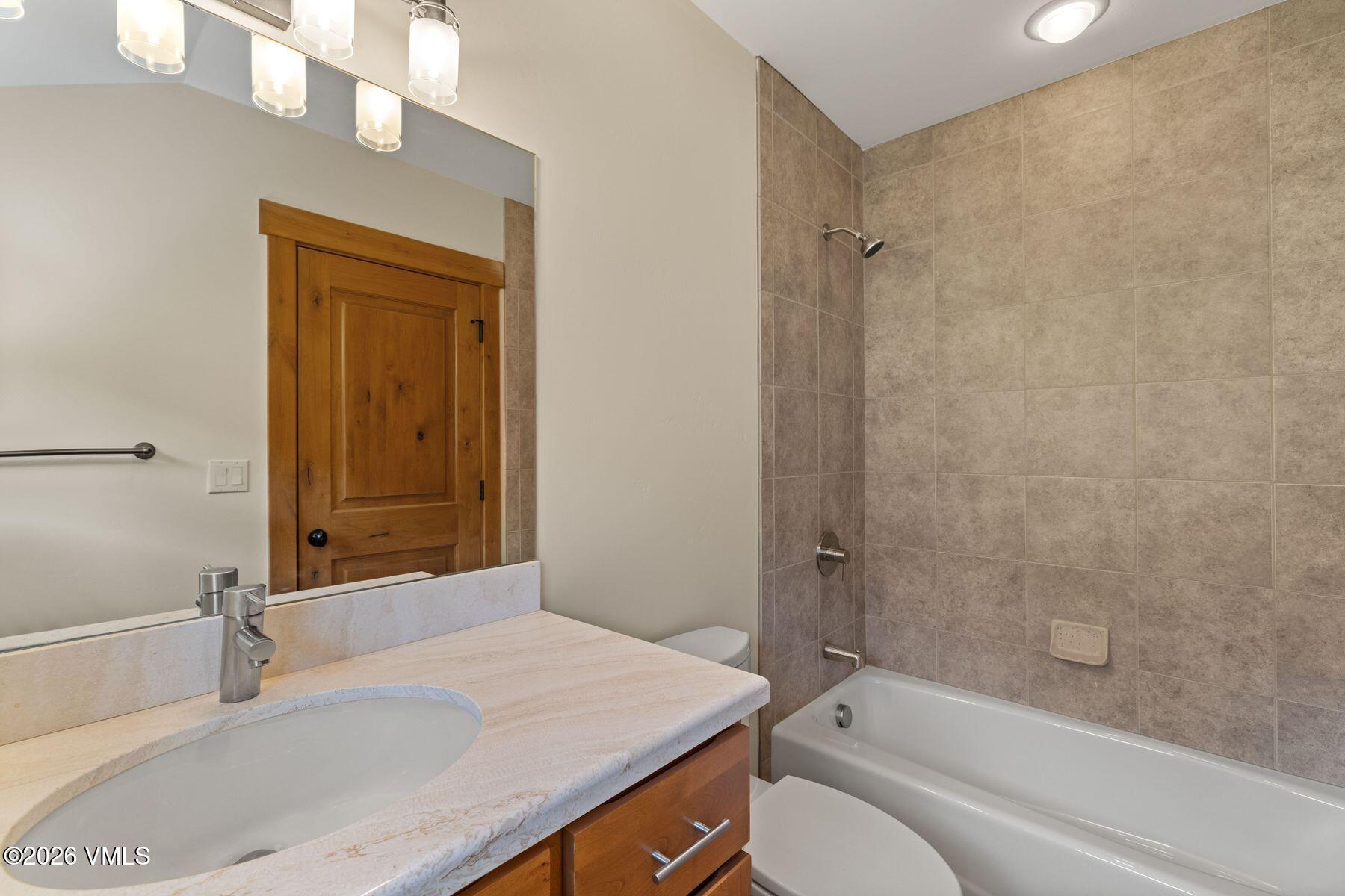 1015 West Wildwood Road, Unit F Avon, CO 81620 - Photo 24 of 35 a bathroom with a granite countertop sink toilet and shower