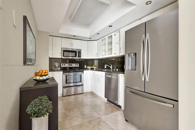 a kitchen with a refrigerator stainless steel appliances and cabinets