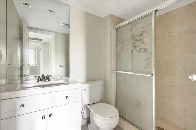 a bathroom with a granite countertop sink toilet a mirror and shower