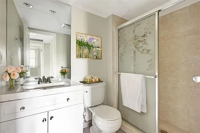 a bathroom with a sink a toilet a shower and a mirror