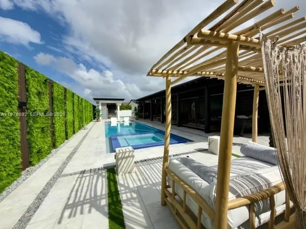 a view of a patio with couple of chairs and a potted plant