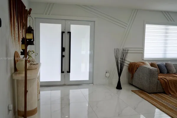 a living room with furniture a flat screen tv and a floor to ceiling window