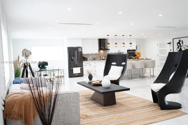 a living room with furniture a rug and white appliances
