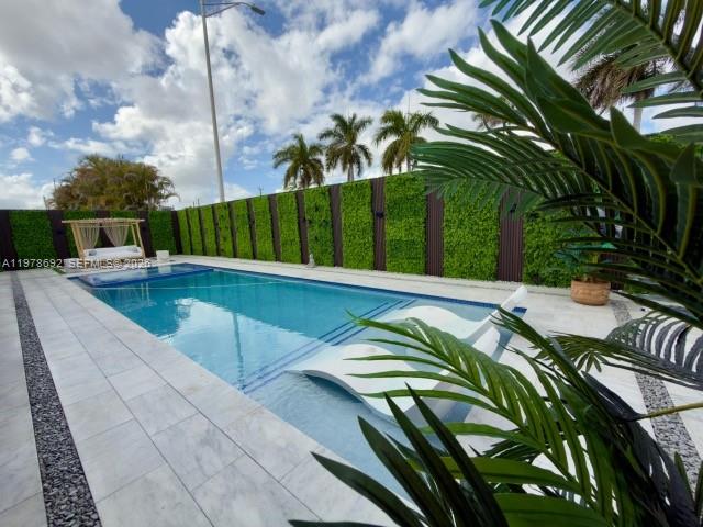 9351 Southwest 88th Terrace Miami, FL 33176 - Photo 8 of 73 a view of a swimming pool with a lounge chairs