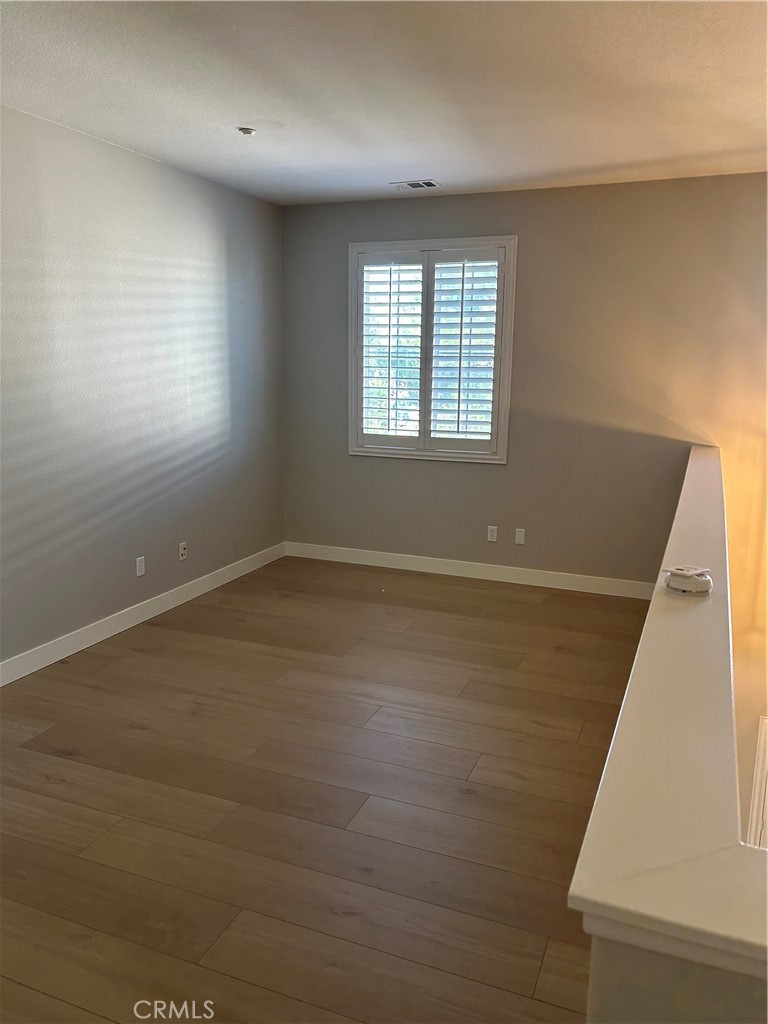 3366 Greenpark Lane Riverside, CA 92503 - Photo 14 of 23 an empty room with wooden floor and windows