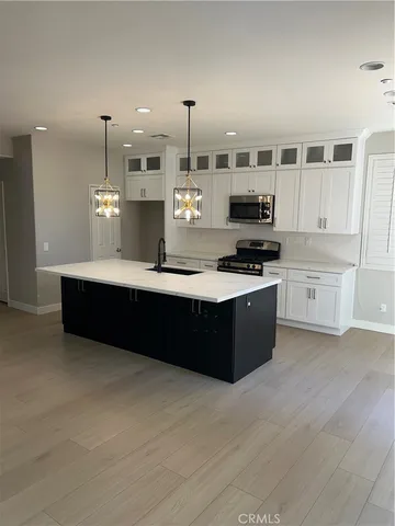 a kitchen with kitchen island a sink stainless steel appliances and cabinets