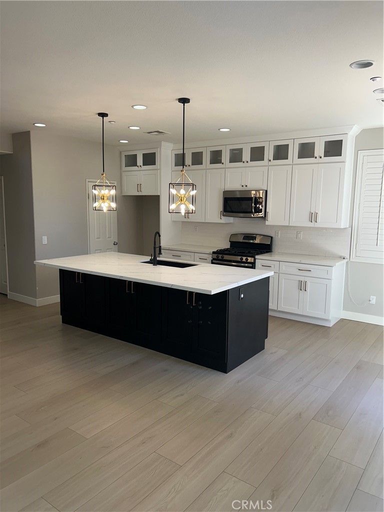 3366 Greenpark Lane Riverside, CA 92503 - Photo 3 of 23 a kitchen with kitchen island a sink stainless steel appliances and cabinets