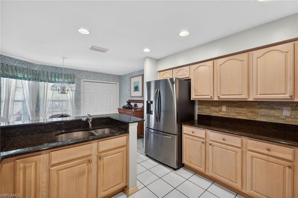 242 Via Perignon, Unit 93 Naples, FL 34119 - Photo 11 of 20 a kitchen with granite countertop white cabinets and refrigerator