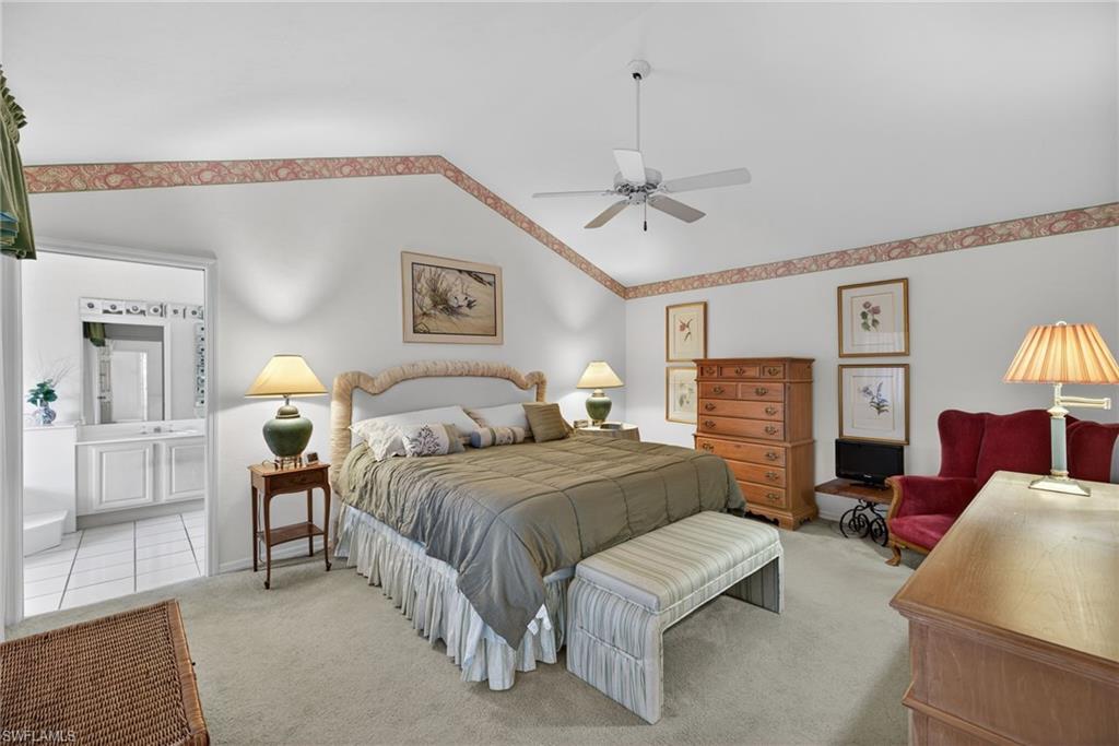 242 Via Perignon, Unit 93 Naples, FL 34119 - Photo 13 of 20 a spacious bedroom with a bed and lamp