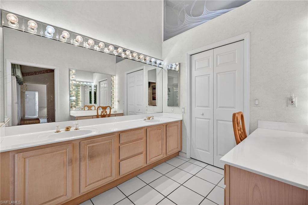 242 Via Perignon, Unit 93 Naples, FL 34119 - Photo 15 of 20 a spacious bathroom with a double vanity sink and a mirror