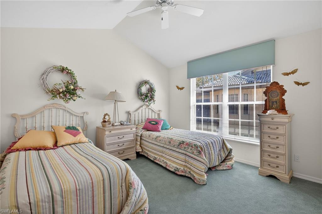 242 Via Perignon, Unit 93 Naples, FL 34119 - Photo 18 of 20 a bedroom with two beds and a chandelier