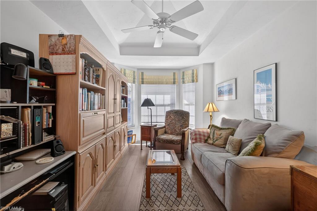 242 Via Perignon, Unit 93 Naples, FL 34119 - Photo 19 of 20 a living room with furniture a fireplace and a book shelf