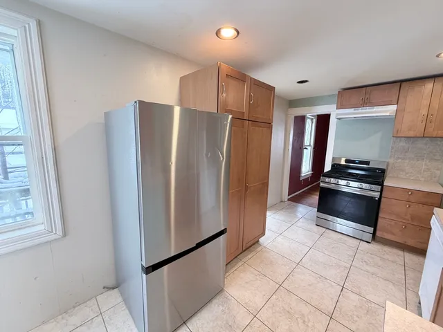 a kitchen with stainless steel appliances granite countertop a refrigerator and a stove