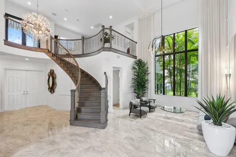 a dining room with furniture a chandelier and kitchen view