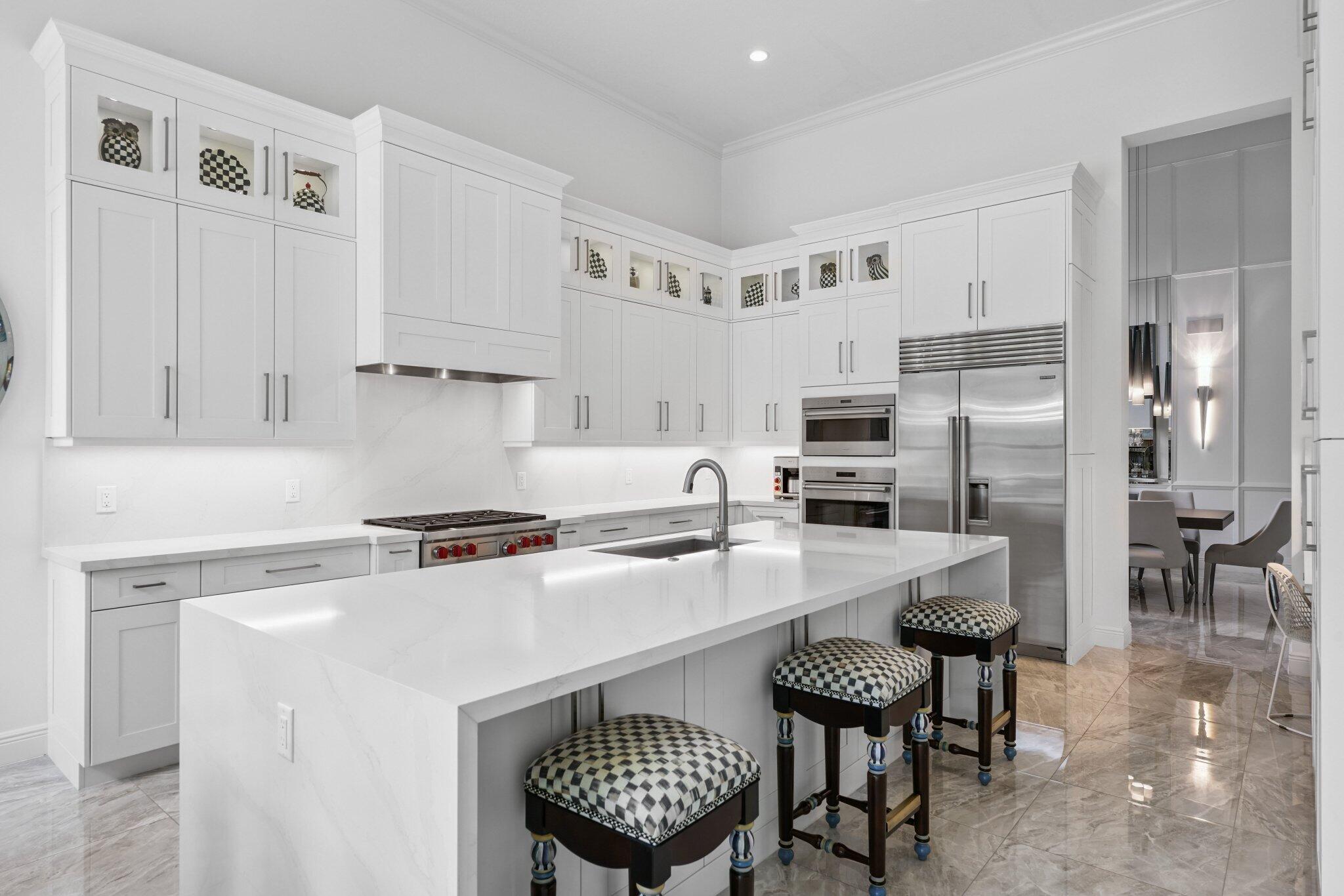 2741 Northwest 70th Boulevard Boca Raton, FL 33496 - Photo 26 of 109 a kitchen with a refrigerator a stove a dining table and chairs