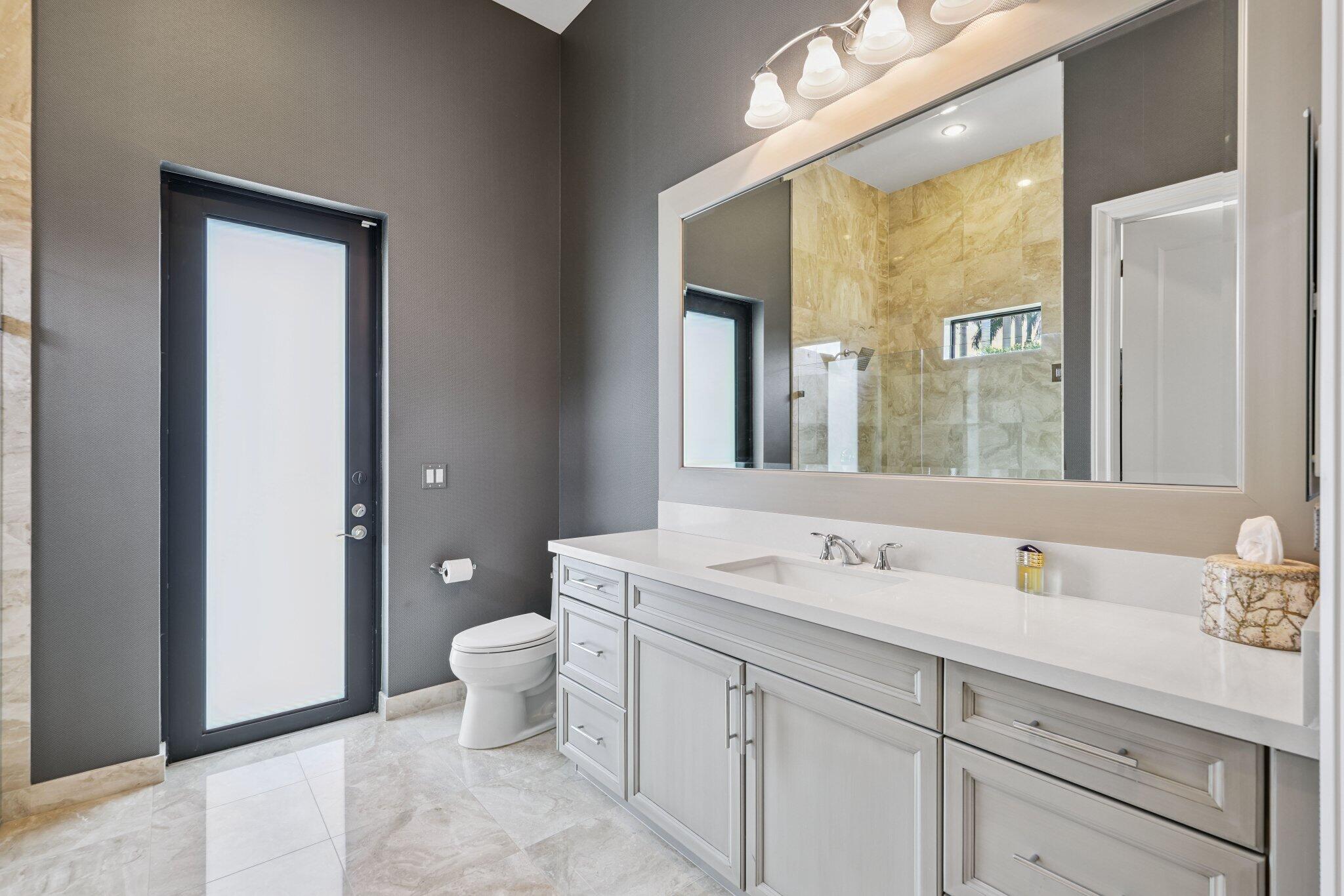 2741 Northwest 70th Boulevard Boca Raton, FL 33496 - Photo 60 of 109 a bathroom with a sink a toilet and a mirror