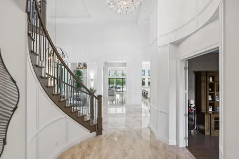 a living room with furniture a clock and a chandelier