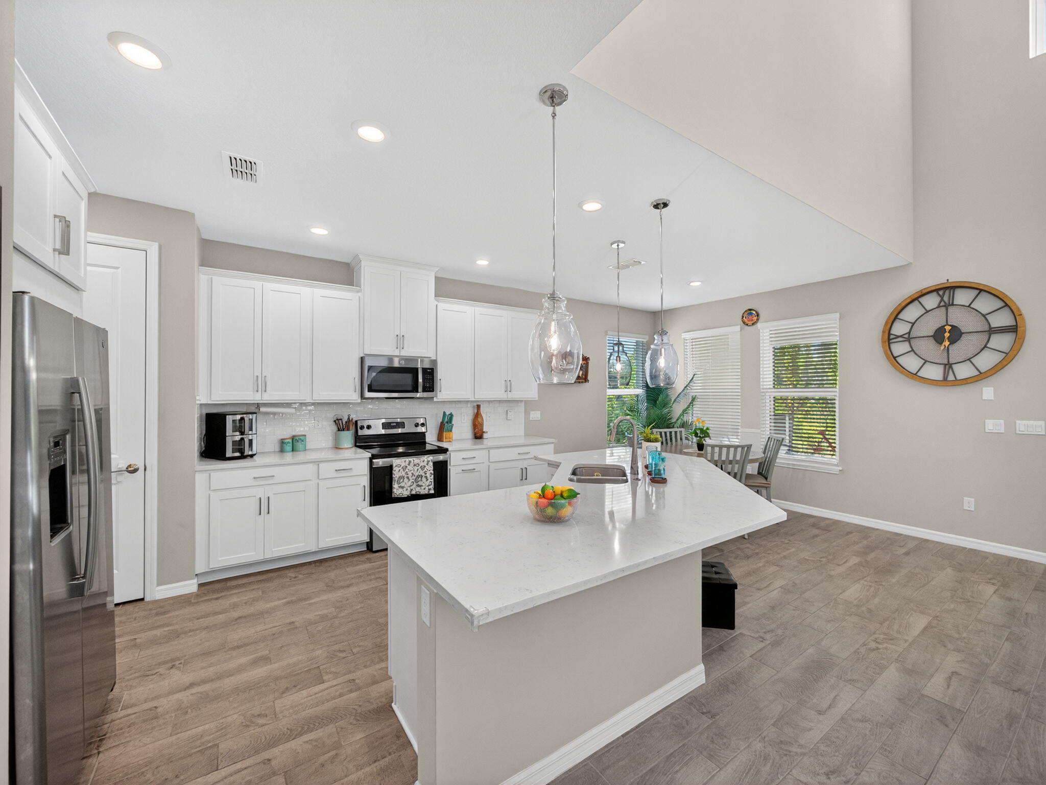 11912 Southwest Macelli Way Port Port St. Lucie, FL 34987 - Photo 7 of 34 a kitchen with stainless steel appliances granite countertop a sink a stove a refrigerator and white cabinets