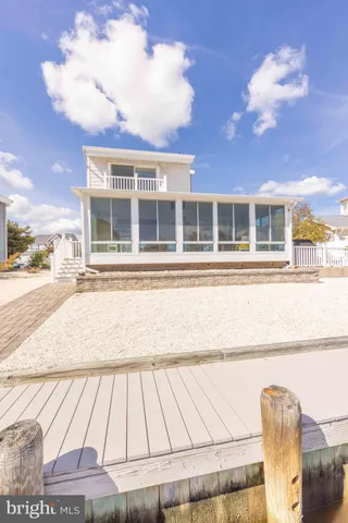 a view of a house with a large tree and wooden fence