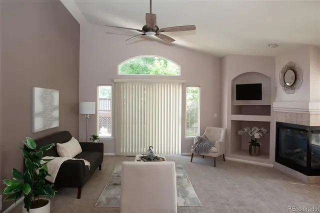 a living room with furniture a fireplace and a large window