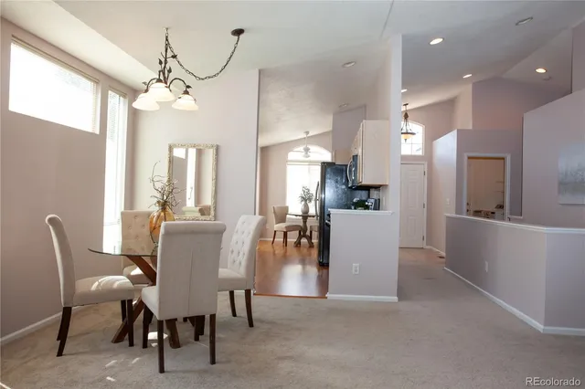 a dining room with furniture a chandelier and kitchen view