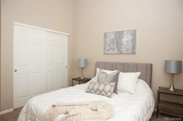 a bedroom with a bed and a lamp on the dresser