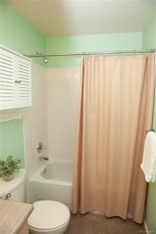 a bathroom with a toilet and a shower curtain
