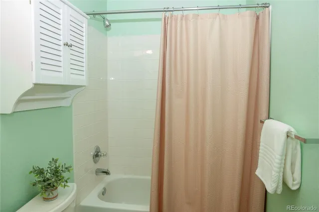a bathroom with a shower curtain and a bathtub