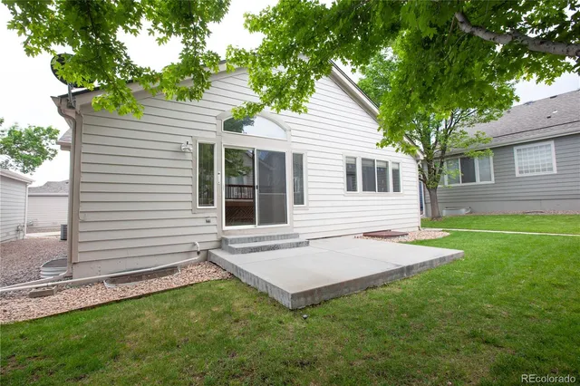 a view of a house with a yard and tree