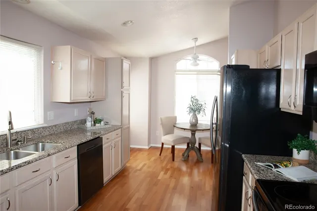 a kitchen with a sink dishwasher a stove a refrigerator with wooden cabinets and floor