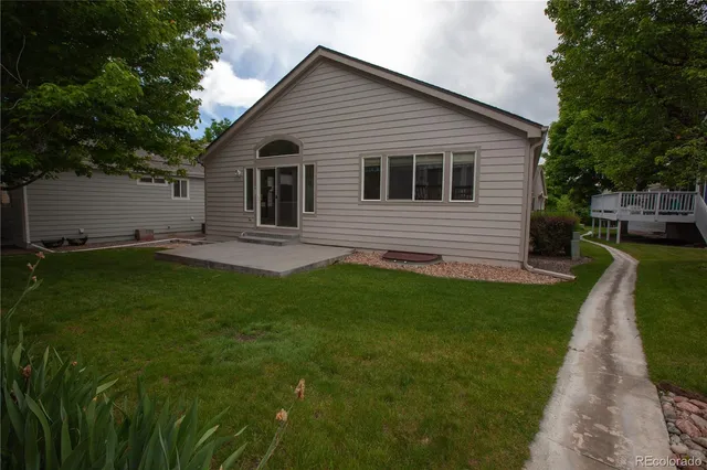 a view of a backyard with table and chairs and wooden fence