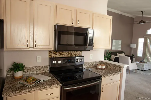 a kitchen with granite countertop a stove and a microwave