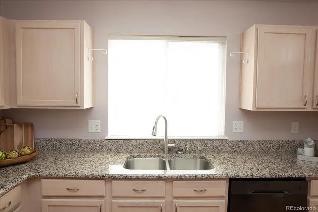 a kitchen with granite countertop a sink and cabinets
