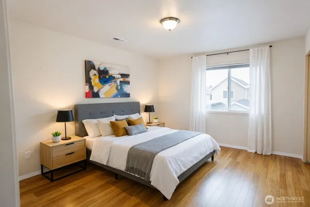 a bedroom with a bed and wooden floor