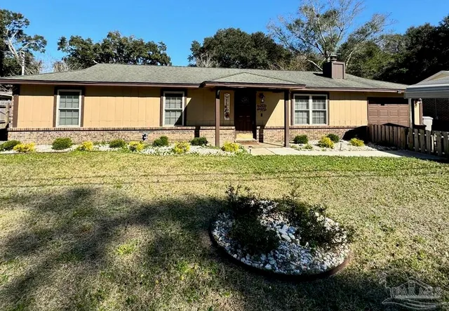 a view of a house with backyard and sitting area