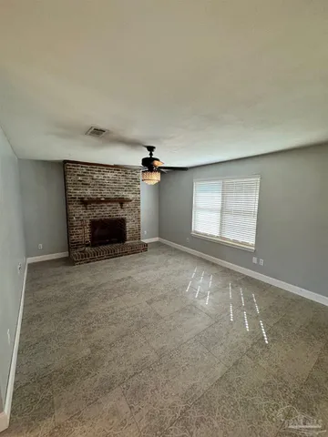 an empty room with fireplace and a window