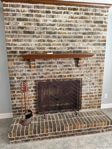 an empty room with windows and chandelier fan