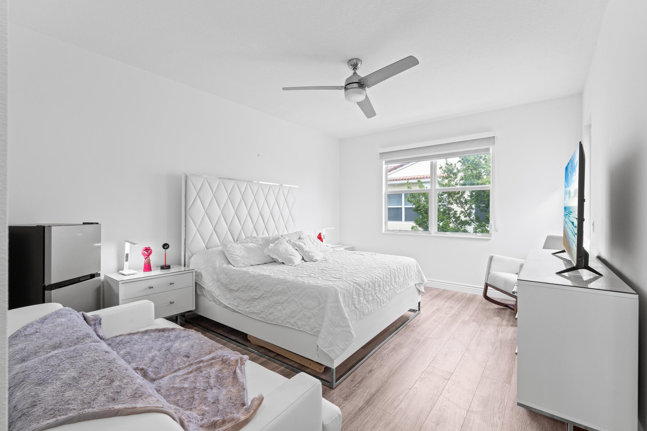 5010 Northwest 16th Way Boca Raton, FL 33431 - Photo 11 of 42 a bedroom with a bed and a flat tv screen on a dresser