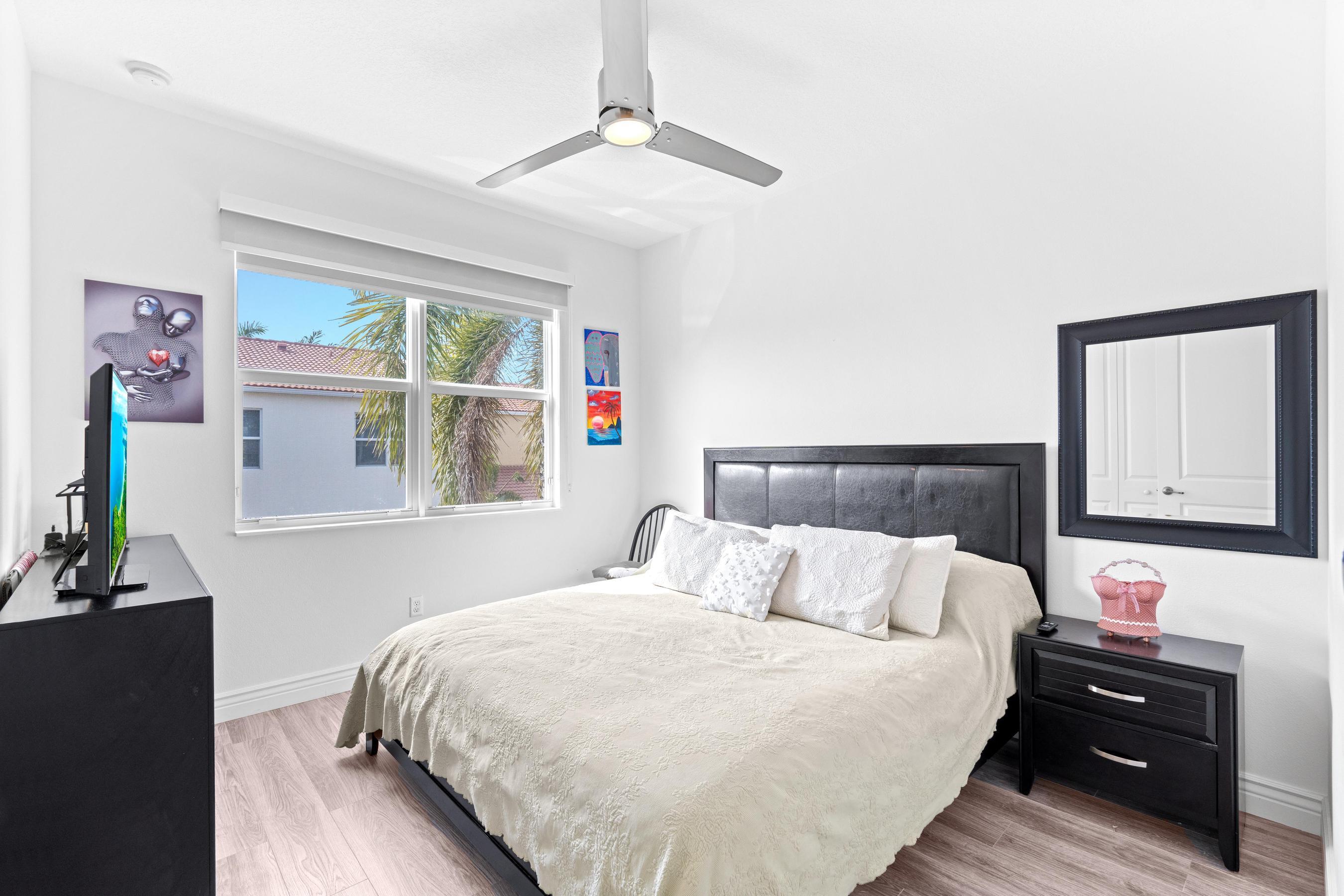 5010 Northwest 16th Way Boca Raton, FL 33431 - Photo 14 of 42 a bedroom with a bed and wooden floor