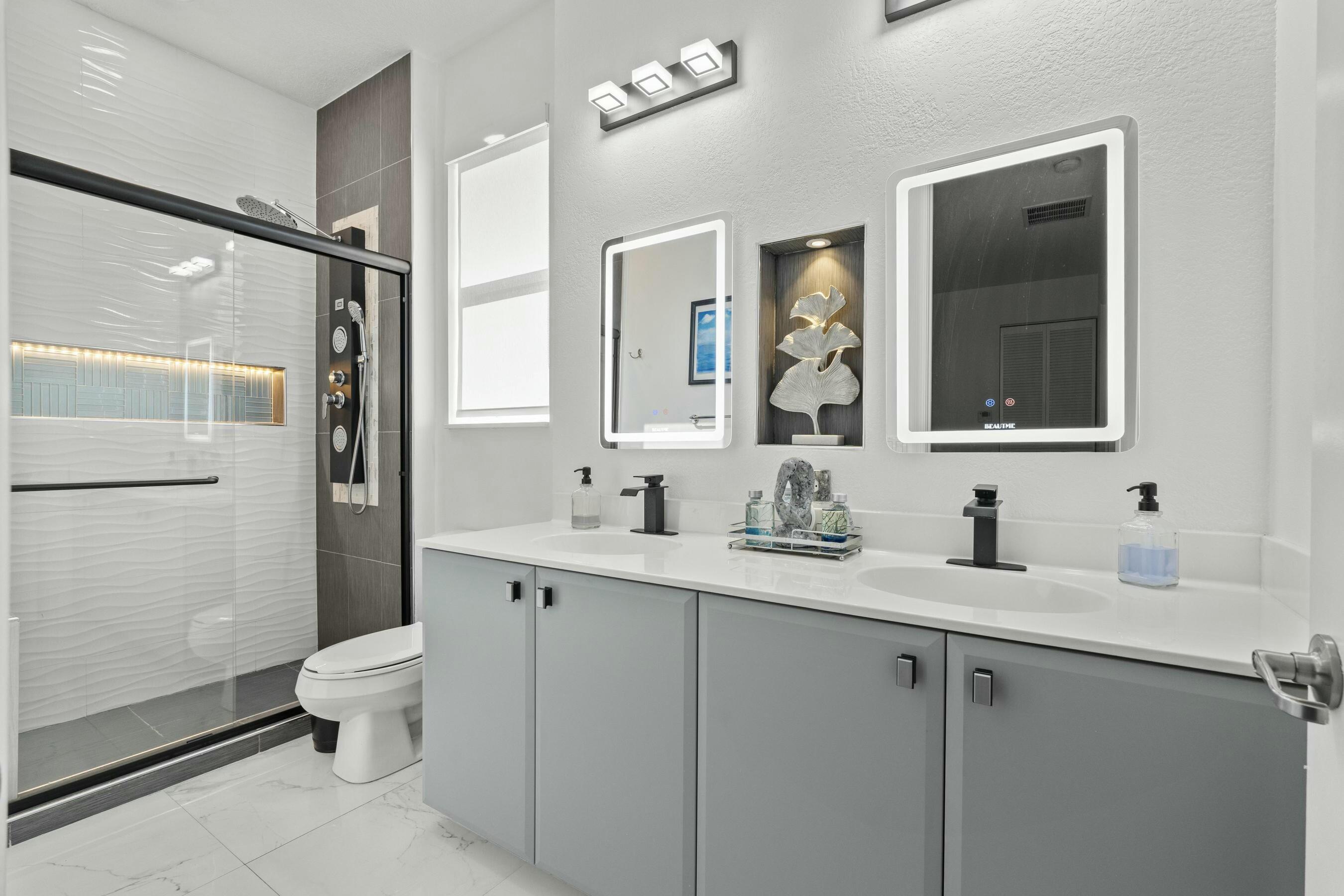 5010 Northwest 16th Way Boca Raton, FL 33431 - Photo 20 of 42 a bathroom with a double vanity sink toilet mirror and shower