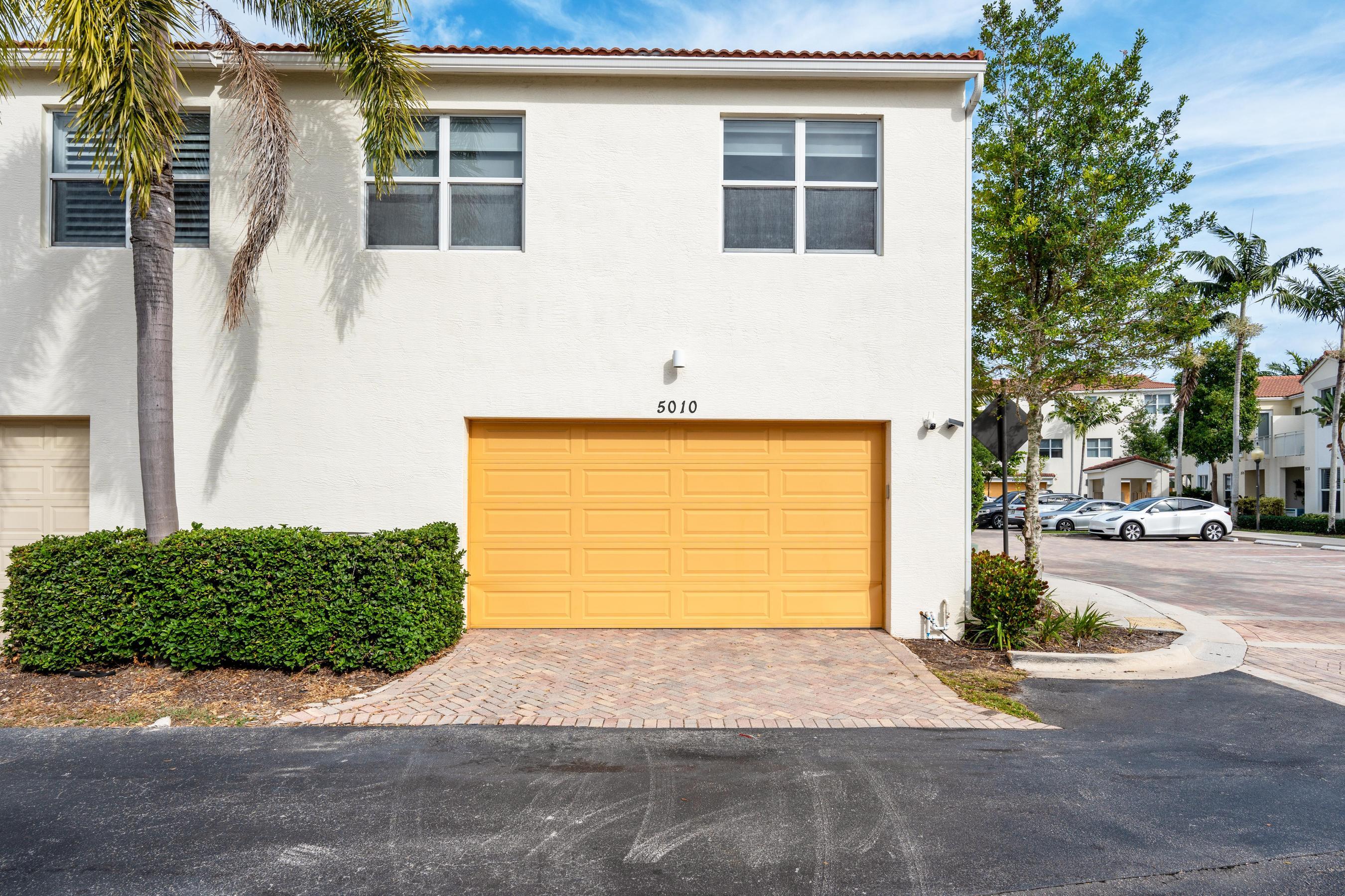 5010 Northwest 16th Way Boca Raton, FL 33431 - Photo 32 of 42 a front view of a house with a yard and garage