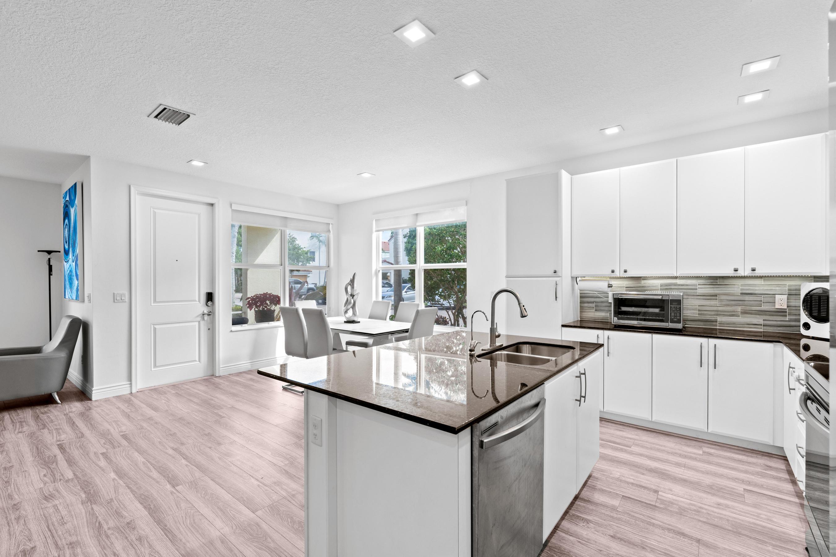 5010 Northwest 16th Way Boca Raton, FL 33431 - Photo 8 of 42 a kitchen with stainless steel appliances granite countertop a sink stove and cabinets